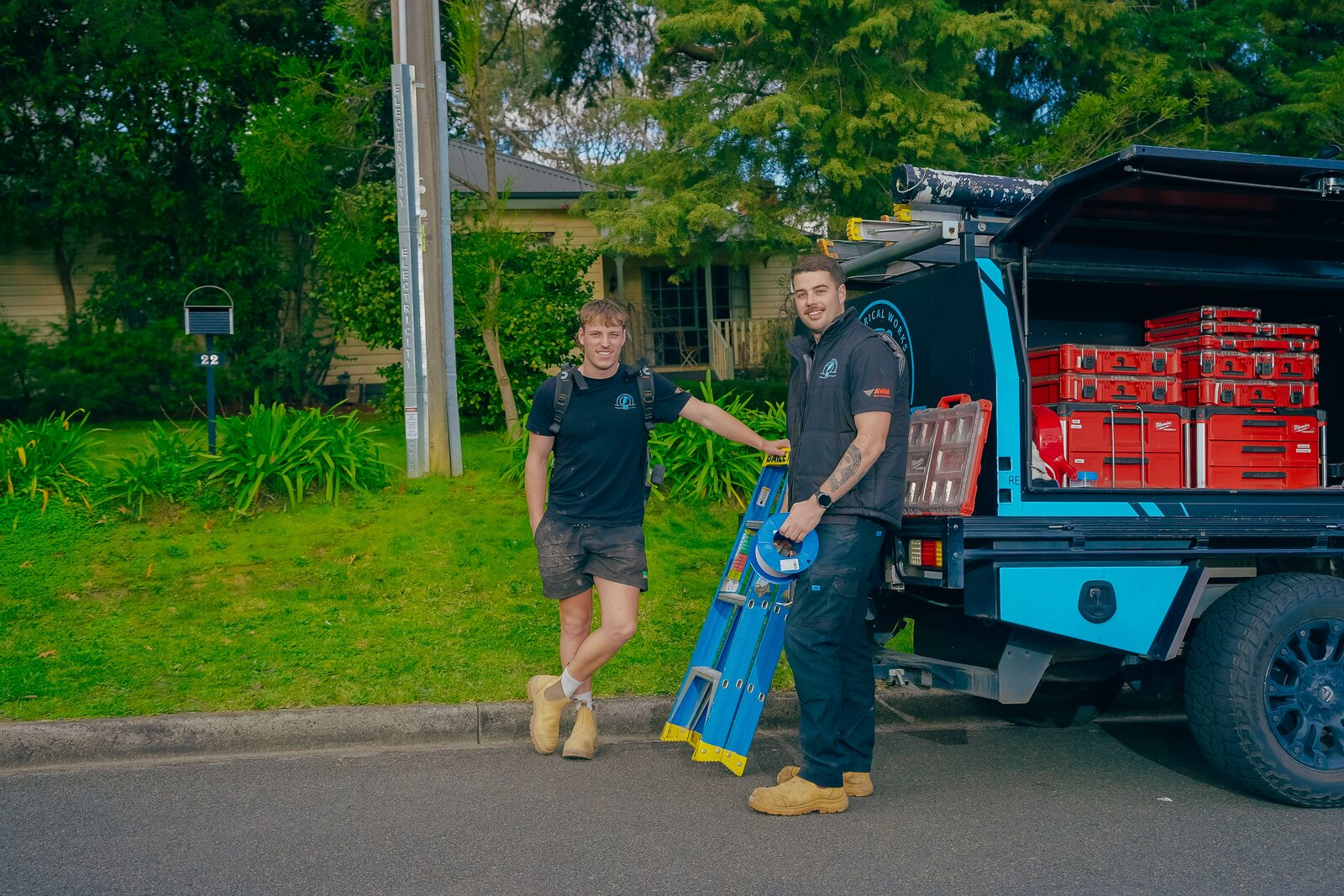 Josh Povey and Lachy unloading a ladder from the 22 Electrical Works ute